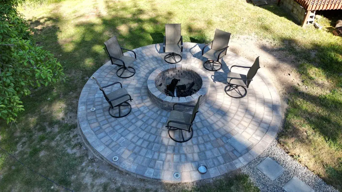 Circular paver patio with fire pit and swivel chairs