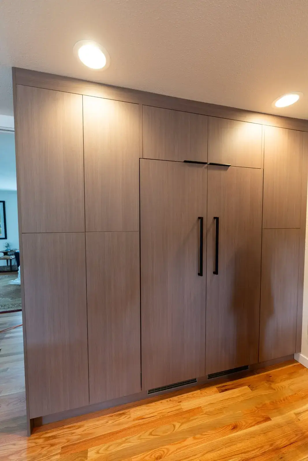 Full-height walnut pantry wall with a panel-ready fridge