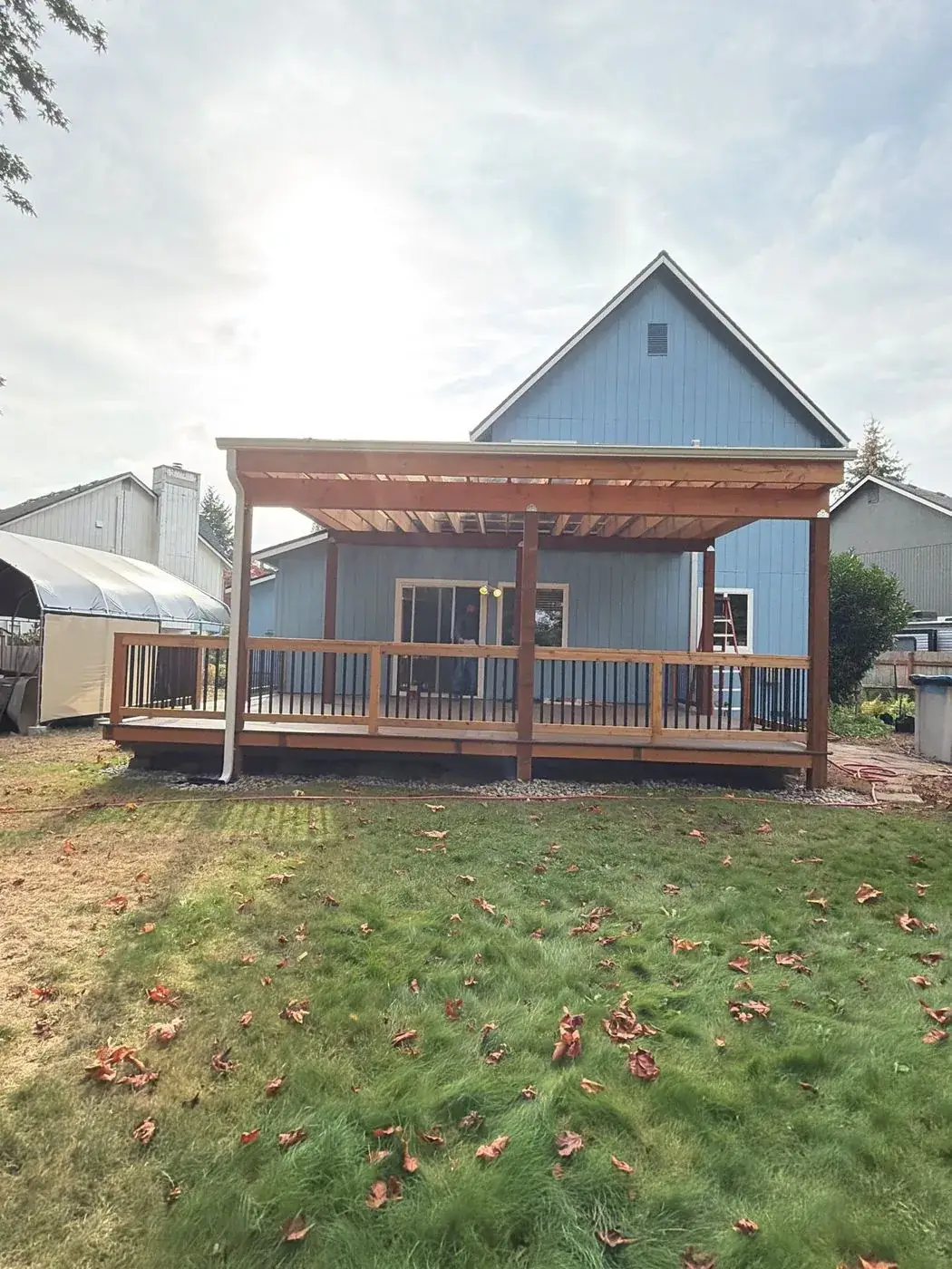 Covered deck with cedar beams across the back of the house