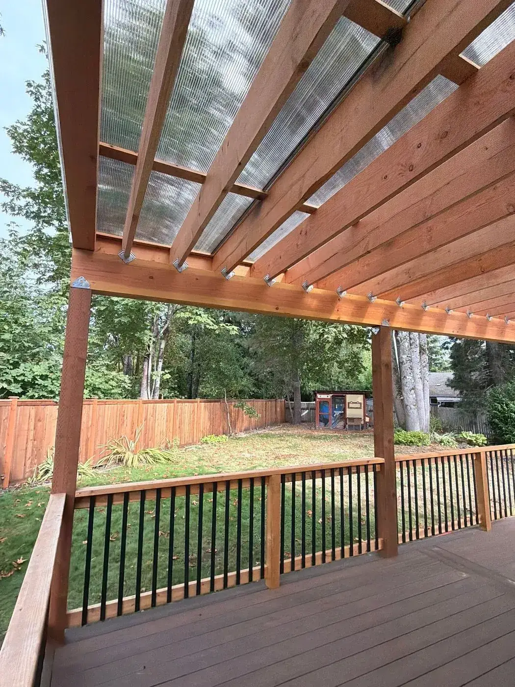 Covered deck with cedar beams and black balusters