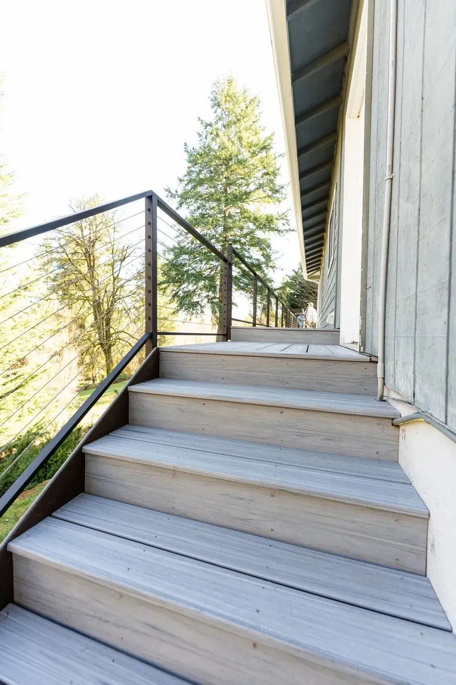 Composite deck stairs with cable railing along an Olympia home