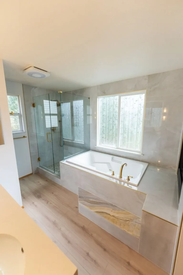 Primary bath with glass shower, tub deck and wood-look floor – Bathroom remodel in Renton, WA by NW Expert Builders