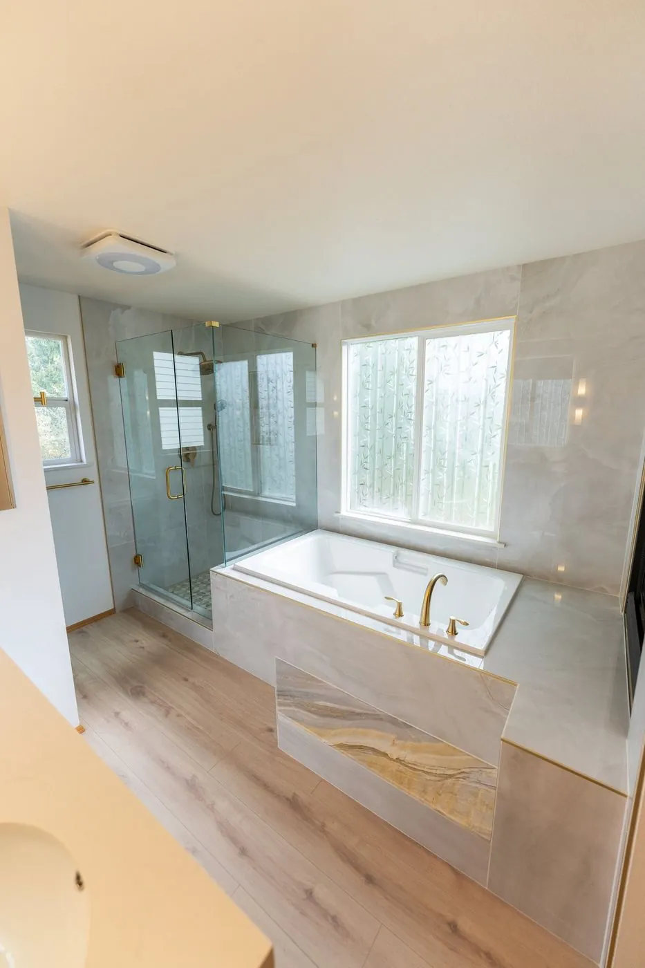 Primary bath with a glass shower, soaking tub and fireplace in Renton