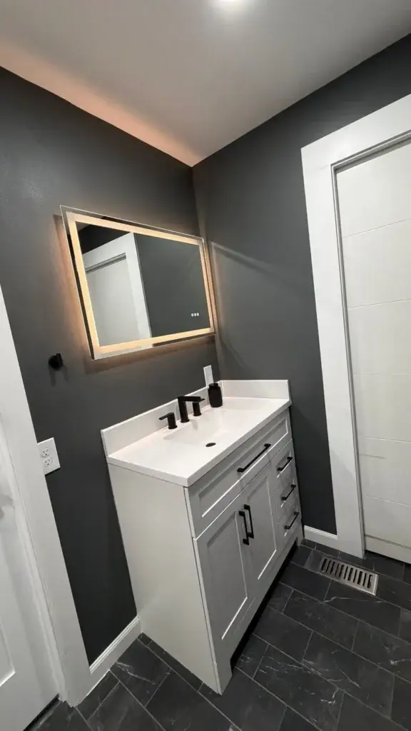 White vanity with LED mirror against charcoal walls – Bathroom remodel in Renton, WA by NW Expert Builders
