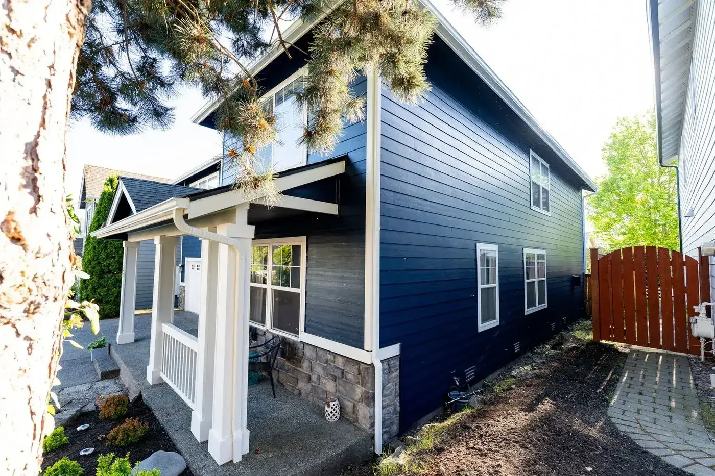 Home with new navy siding and a covered porch