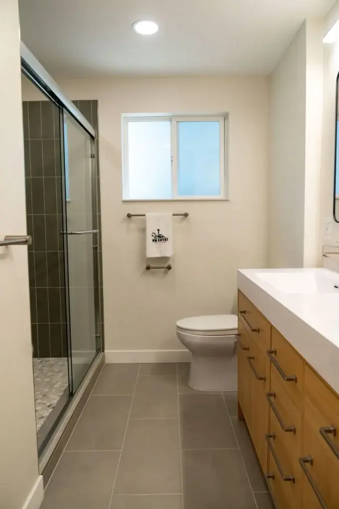 Full view: oak vanity, sliding glass shower and window – Bathroom remodel in Shoreline, WA by NW Expert Builders