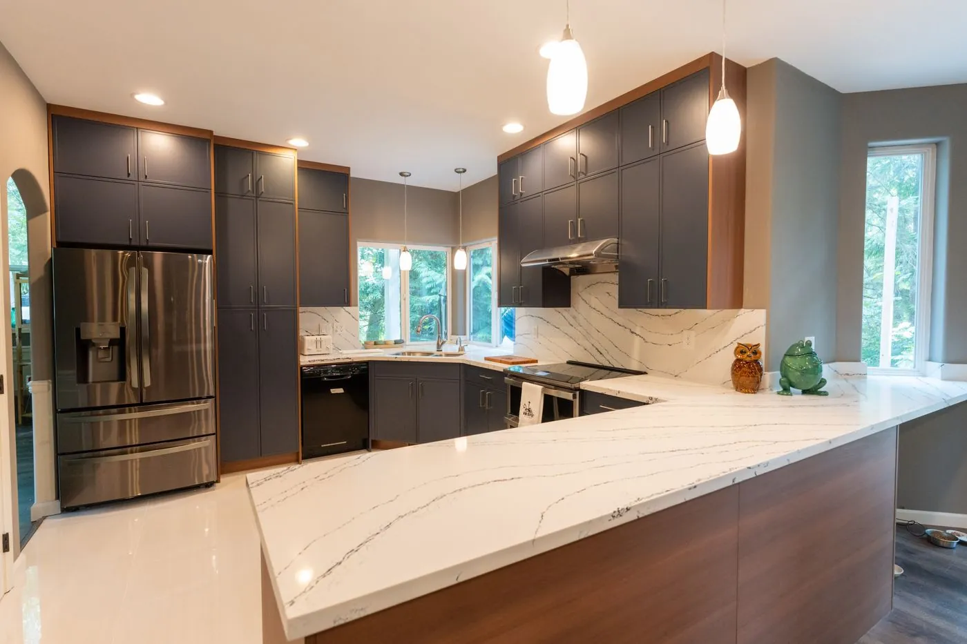 Navy U-shaped kitchen with a walnut peninsula