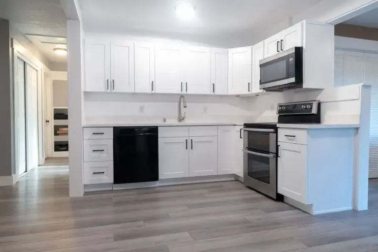 L-shaped white shaker kitchen with quartz and wood-look floors – Kitchen & Bathroom remodel in Tacoma, WA by NW Expert Builders