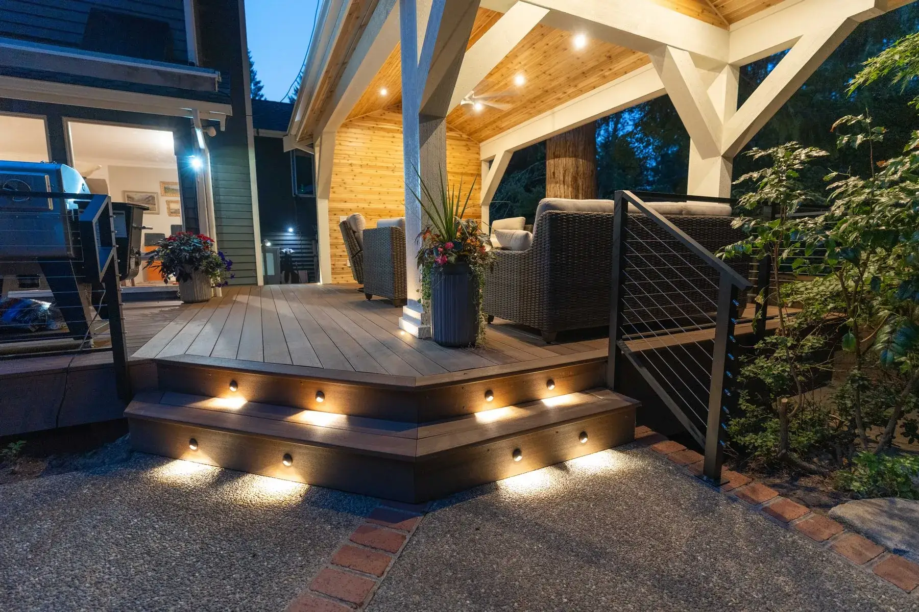 Lit deck steps rising to a cedar-lined pavilion at dusk